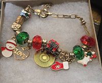 Full view of gold-tone bracelet showing all holiday charms, beads and lobster clasp