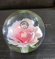 Front view showing internal pink and white rose with green leaves inside clear glass sphere