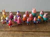 Full group of 17 Peppa Pig figures on wooden surface