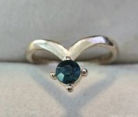 Front view of silver-plated chevron ring with teal rhinestone