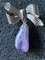 Front view showing bow shape, texture, and amethyst drop