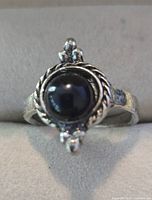 Front view of silver-plated ring with black cabochon and rope bezel