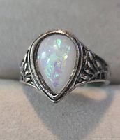 Front view of ring showing pear-shaped opalescent glass stone and bezel