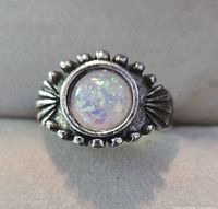 Front view of ring showing opal cabochon, bezel, and decorative border