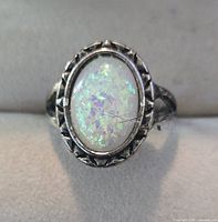 Front view of ring highlighting oval synthetic opal and bezel detail