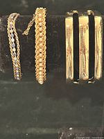 Group shot of all three bracelets standing upright on display form