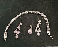 Overview of bracelet, pendant and earrings showing design and stones