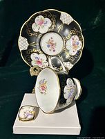 Front of cup, saucer and brooch showing pattern detail