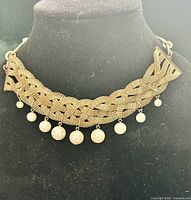 Choker on display showing braided mesh and pearl drops