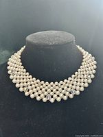 Full view of woven faux pearl collar necklace on display bust