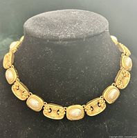 Front view of entire choker on display form showing scroll links with faux pearls