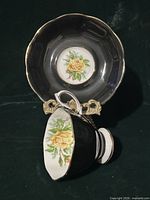 Teacup interior and saucer center showing yellow rose design and gold trim