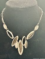 Full necklace on display bust showing overall design and chain