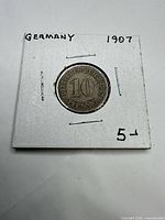 Full view of coin in 2x2 holder showing country and date written on holder
