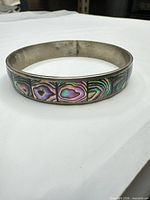 Full view of bangle showing abalone shell mosaic exterior
