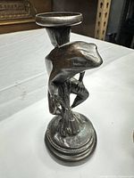 Front view of bronze frog candlestick