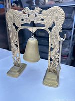 Front view of brass bell hanging in double-dragon frame