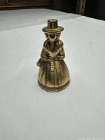 Front view of brass lady figurine bell