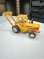 Side view showing Sanderson logo, cab, tyres and rear boom