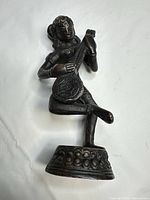 Front view of bronze figurine showing full pose and base