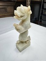 Front view of full jade sculpture showing overall form and color