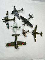 All seven diecast airplanes laid out on white background