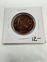 Obverse view of coin in flip showing bust and Arabic script