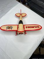 Top view of beige and red Gilmore tin airplane showing wings and propeller