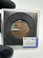 Obverse of coin in plastic holder showing portrait and date