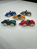 All five metal/tin race cars arranged on tabletop