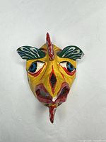 Front view of yellow papier-mâché mask