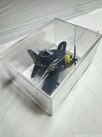 Toy airplane inside clear display case, top angle