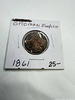 Front of 2x2 holder showing coin reverse with Arabic script, handwritten notes 'Ottoman Empire 1861 25'