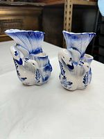 Front view of both blue and white ceramic swan vases