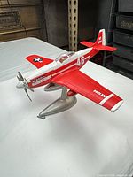 Left-front view of plastic Detroit Miss model airplane on grey stand