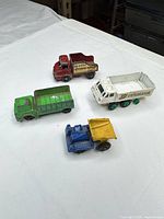 Four of the five toy trucks arranged on table