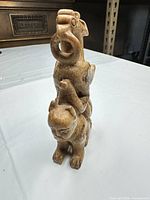 Front view of stacked stone animals showing carving detail and color