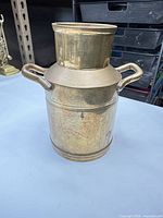 Front view of brass milk can with handles