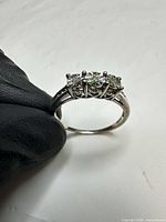Side profile of sterling silver ring showing three CZ stones in prong setting