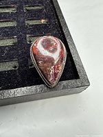 Top view of sterling silver ring showing teardrop red jasper stone and bezel setting