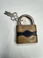 Front view of Yale 635 brass padlock with attached key and tag