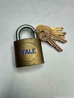 Front view showing Yale logo on brass padlock with keys attached