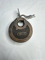 front view of Yale round padlock with key attached