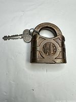 Front view of Yale brass padlock with key attached