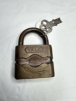 Front view of brass Yale padlock showing logo and maker stamp