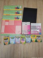 All items laid out together showing paper packs, cardstock pads, black cardstock and seven Crayola crayon boxes