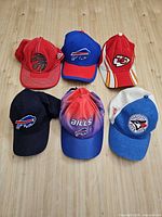 Group shot of six team baseball caps