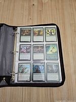 Open binder showing first page of MTG cards