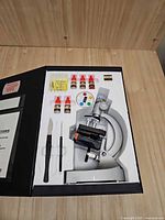 Microscope kit with microscope, slides, bottles, scalpel, tweezer, displayed inside fitted foam case