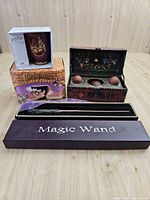 Group shot showing mug in box, wand case, Quidditch chest open with contents